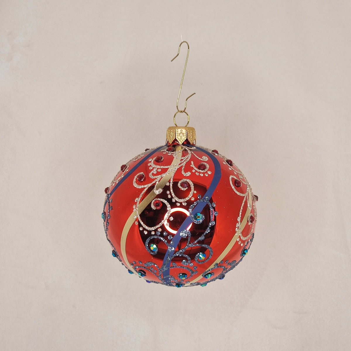 8cm röd kula med guldiga och blåa "swirls" samt dekoration - Julstämning.se