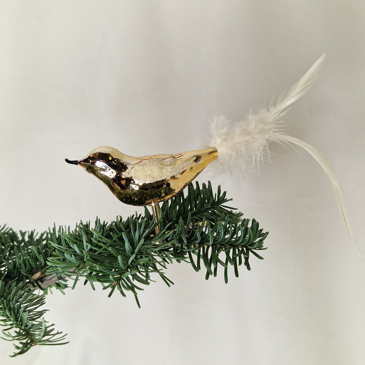 7cm glansig mörkguld fågel med benvita fjädrar - Julstämning.se